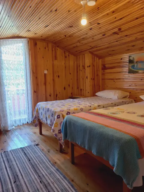 2 Kişilik Oda: Ahşap tavanlı odada yataklar ve pencere