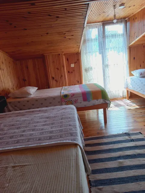 4 Kişilik Oda: Dört kişilik odada yataklar ve geniş pencere