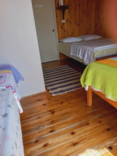4 Kişilik Oda: Ahşap zeminli odada yataklar